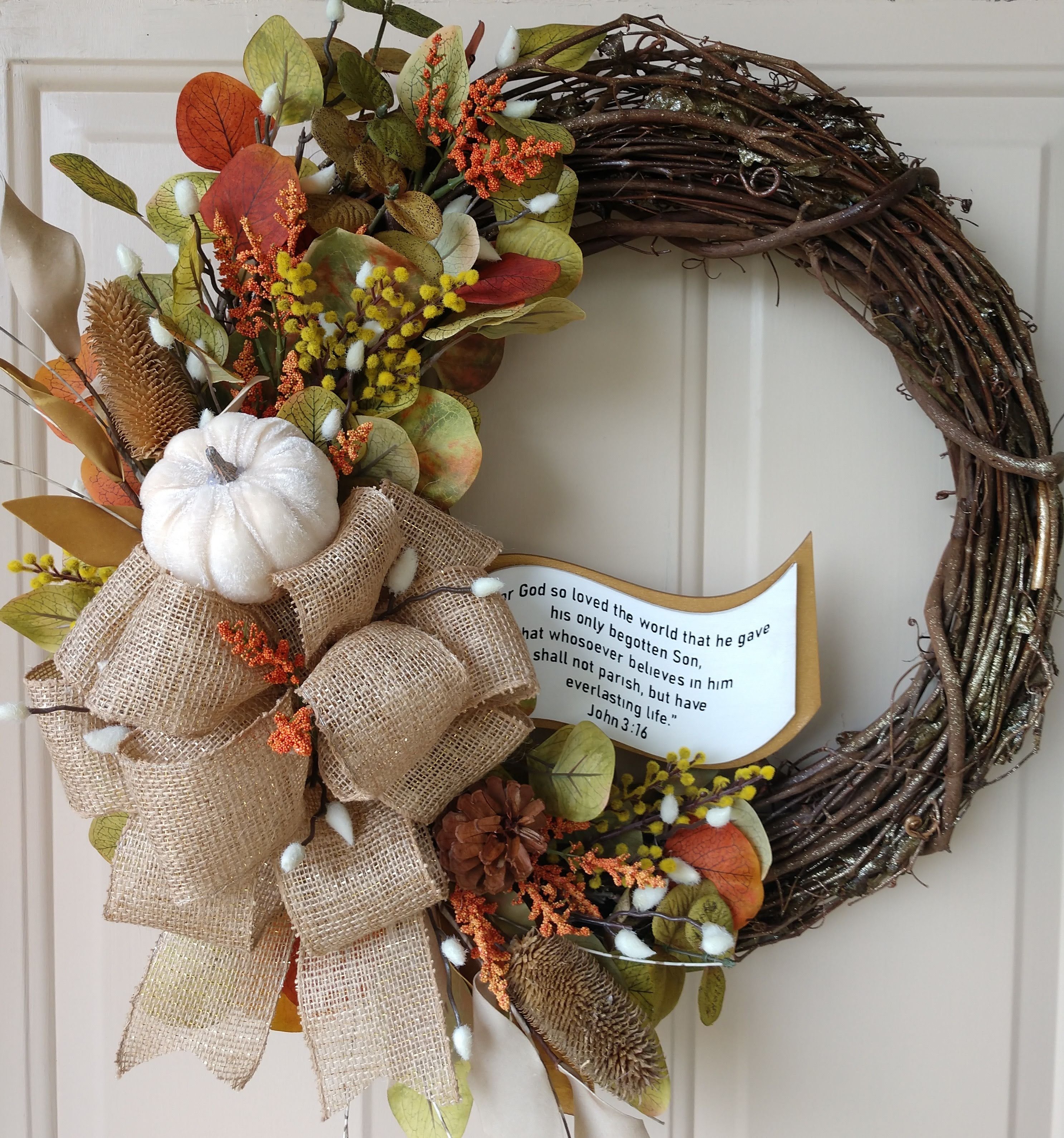 Fall Asymetrical Orange and Green Eucalyptus Leaf Wreath, Accented with White Pumpkin, Beige Burlap Bow, and Orange Trimmings.
